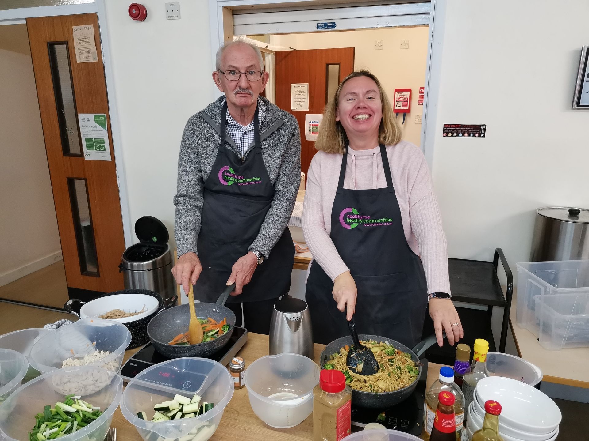 A man and a woman are preparing food in a kitchen.