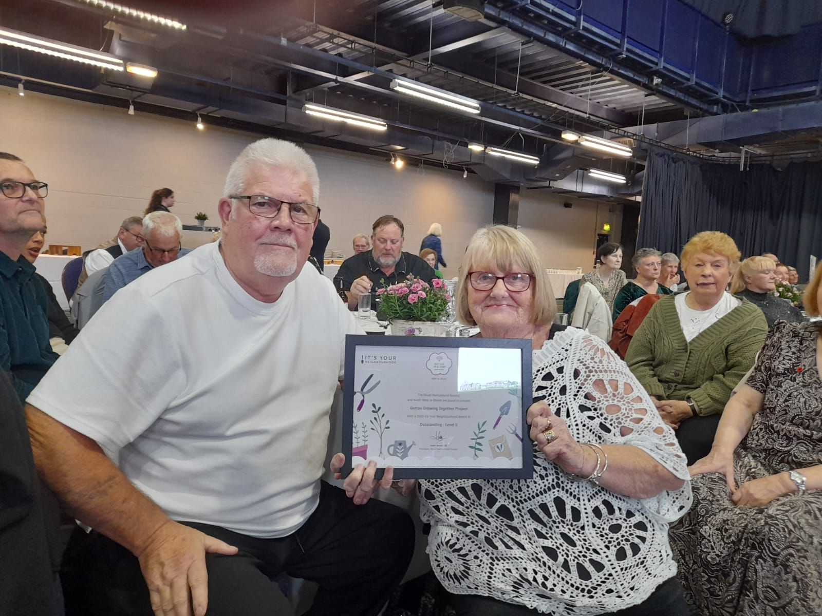 Pat and Gary Lamb hold Gorton Growing Together's 'Gold Award' for 'It's Your Neighbourhood'. Achieving an Outstanding - Level 5.