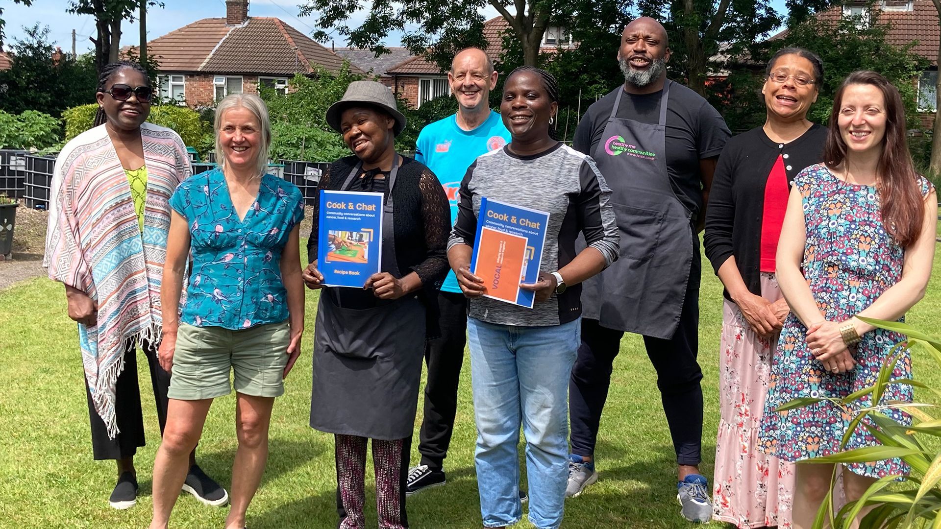 A woman is sitting at a table with a green table cloth that says nuffield health