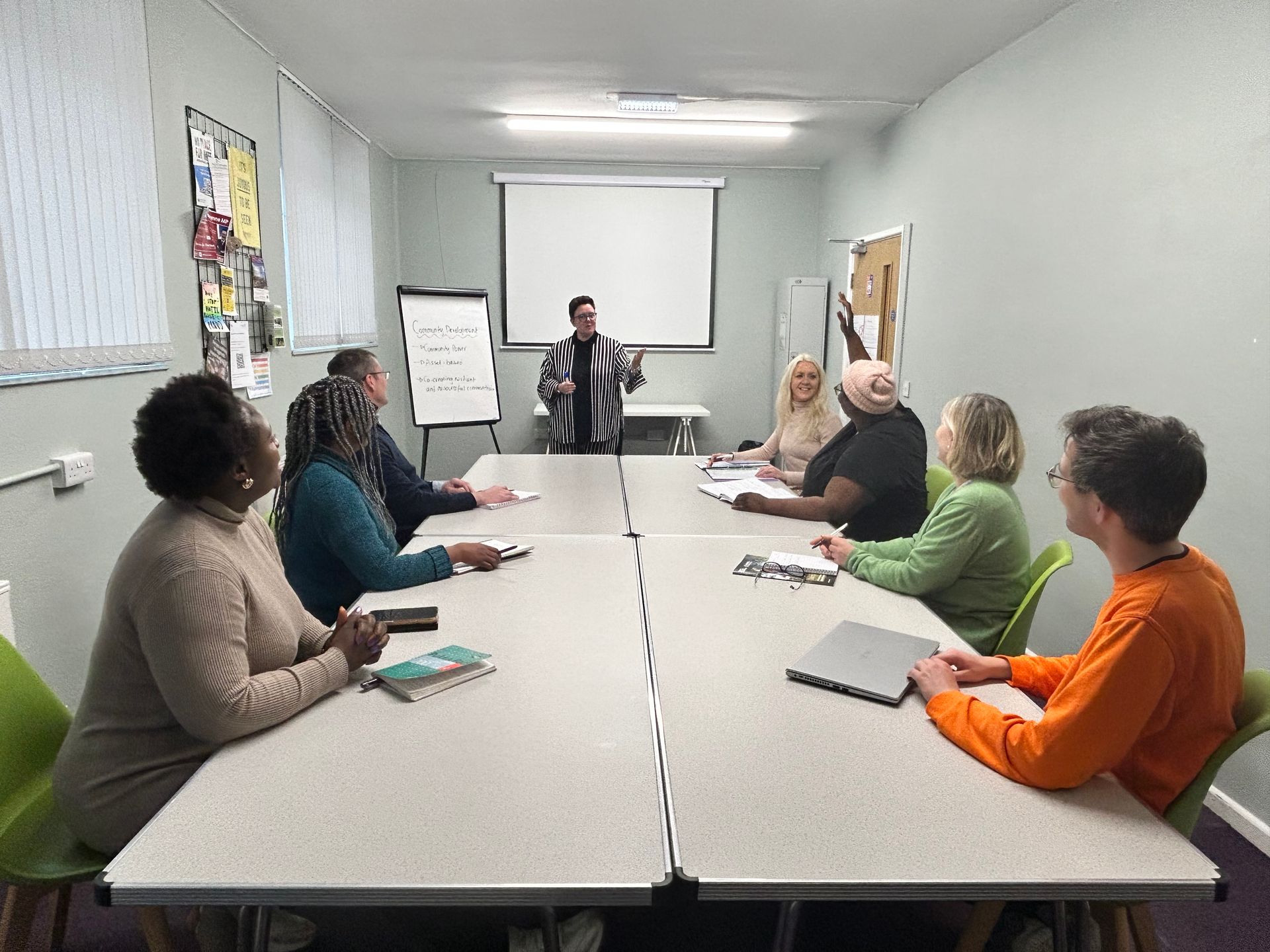 A group of people are sitting around a long table in a conference room.