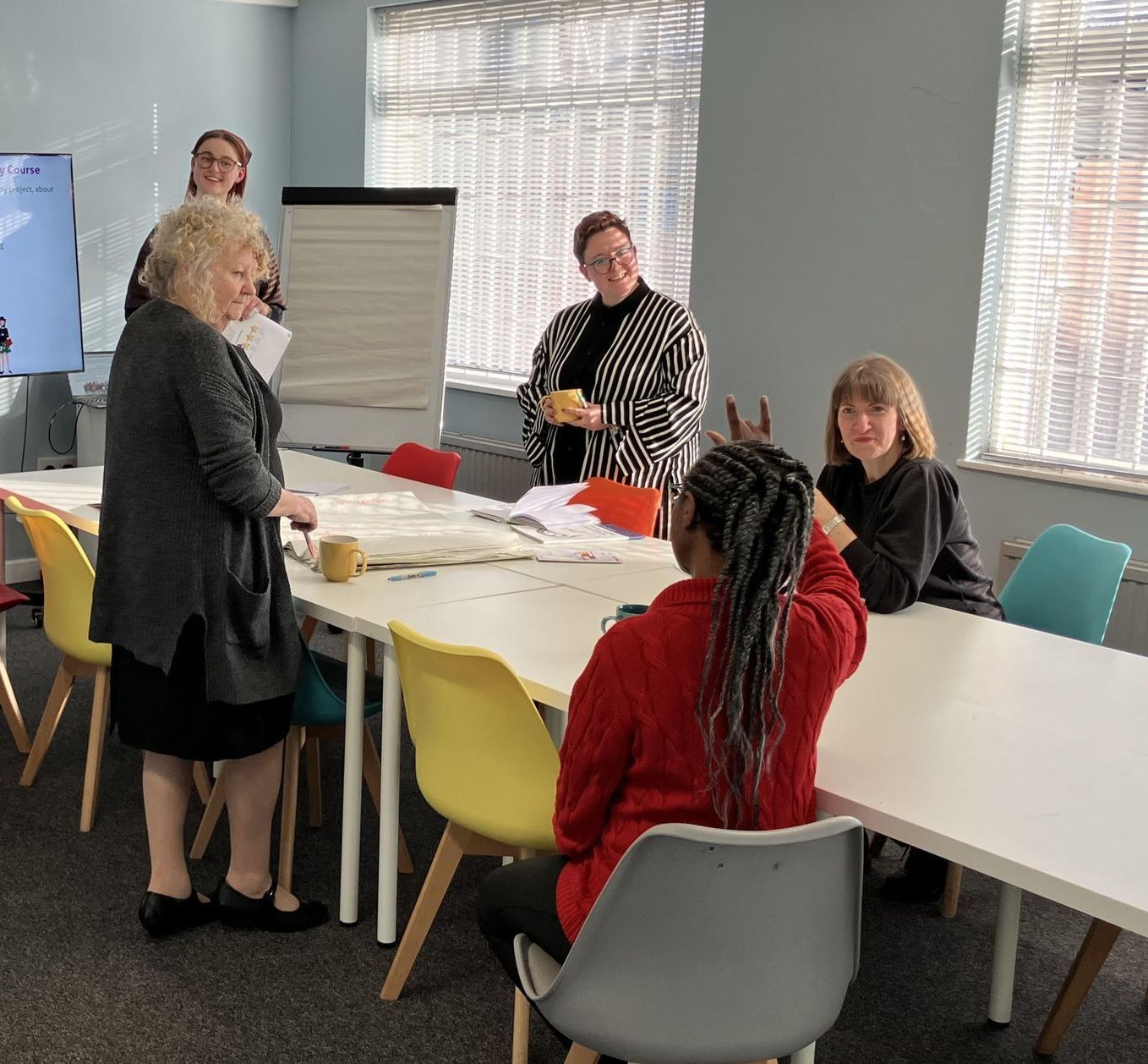 A group of women are sitting around a table in a room