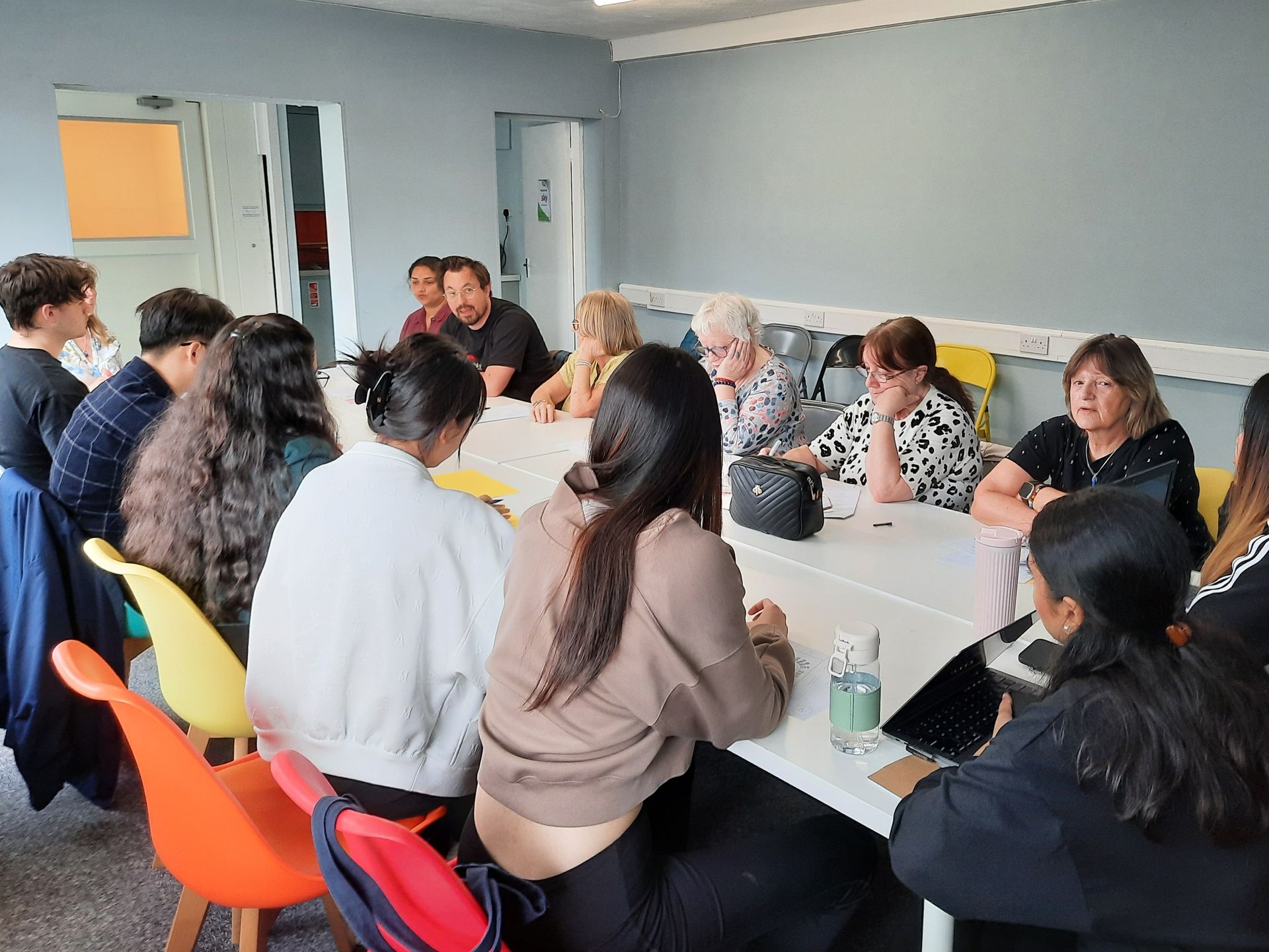 A group of people are sitting around a table in a room.