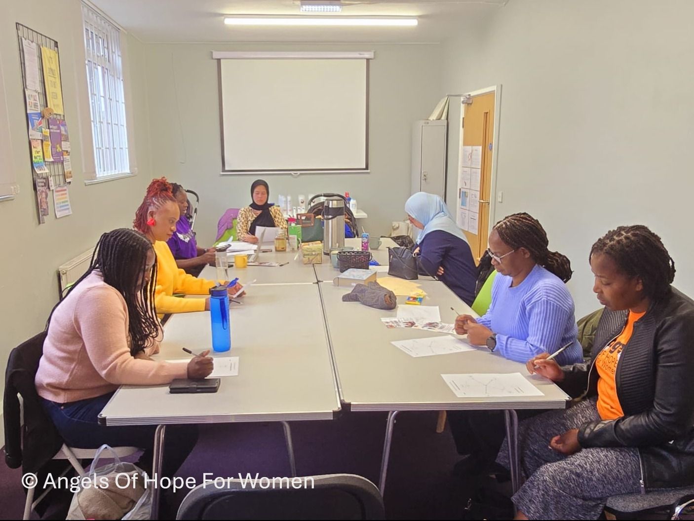 A group of women are sitting at tables in a room.