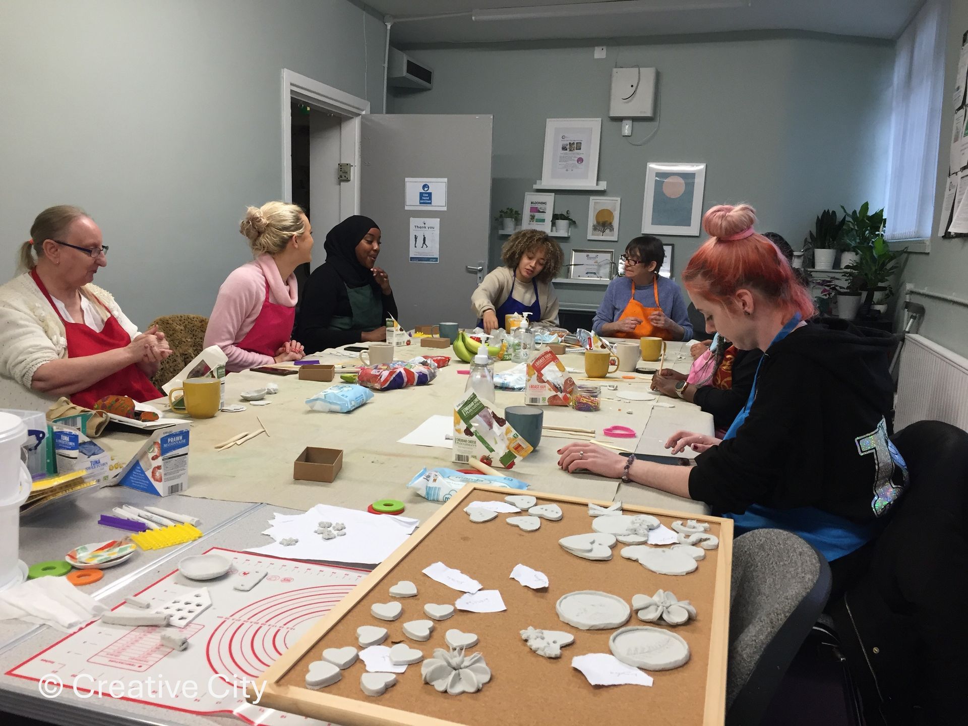 A group of people are sitting around a table making crafts.