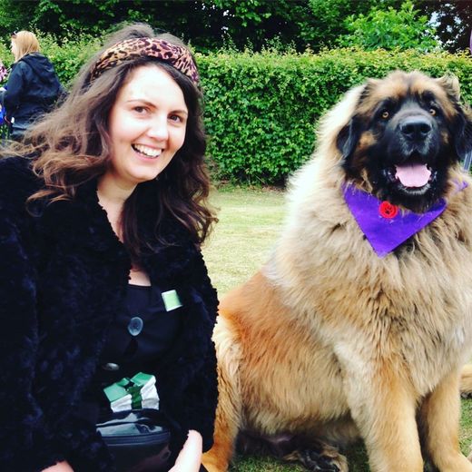 Lisa sitting next to a Leonberger dog