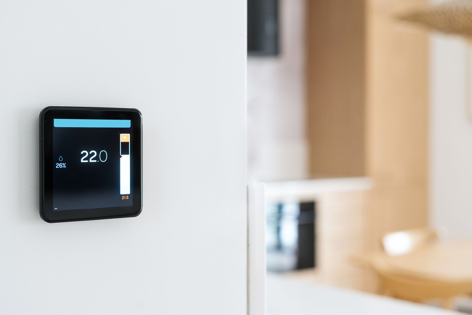 Un termostato intelligente a parete con display digitale nero che mostra una temperatura di 22,0 gradi.