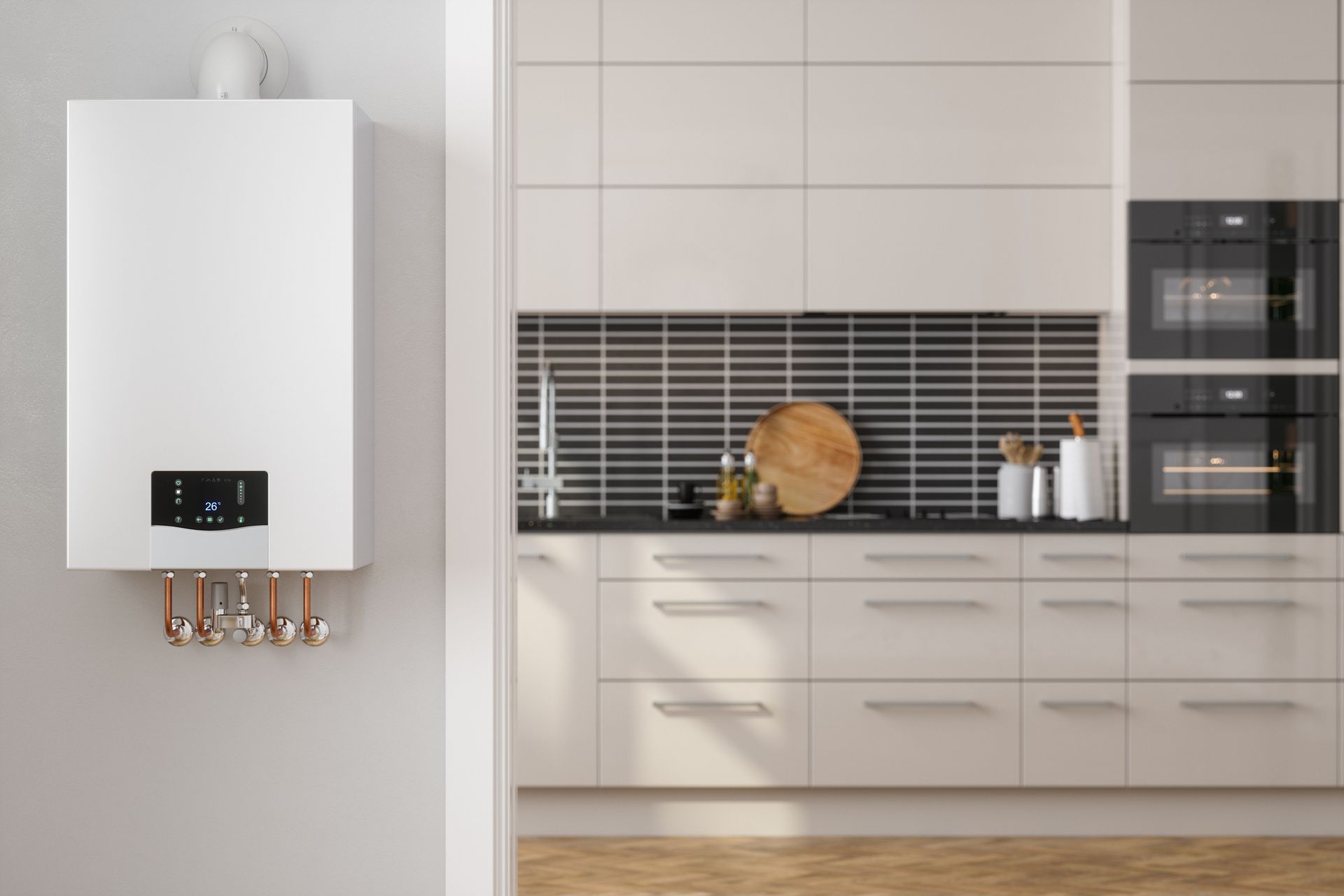 Una caldaia bianca a parete con display digitale installata accanto a una cucina moderna con mobili chiari e piastrelle.