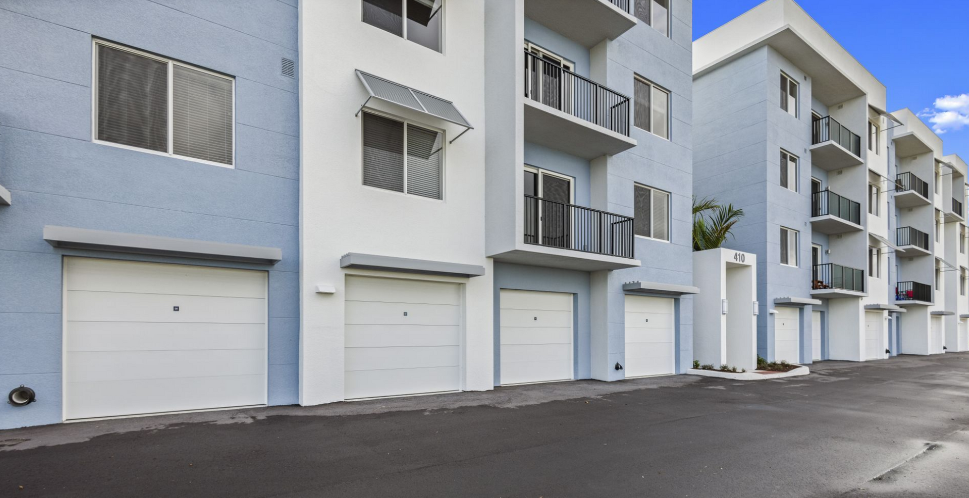 Photo showing a row of the apartment buildings with first floor garages that sit underneath the home