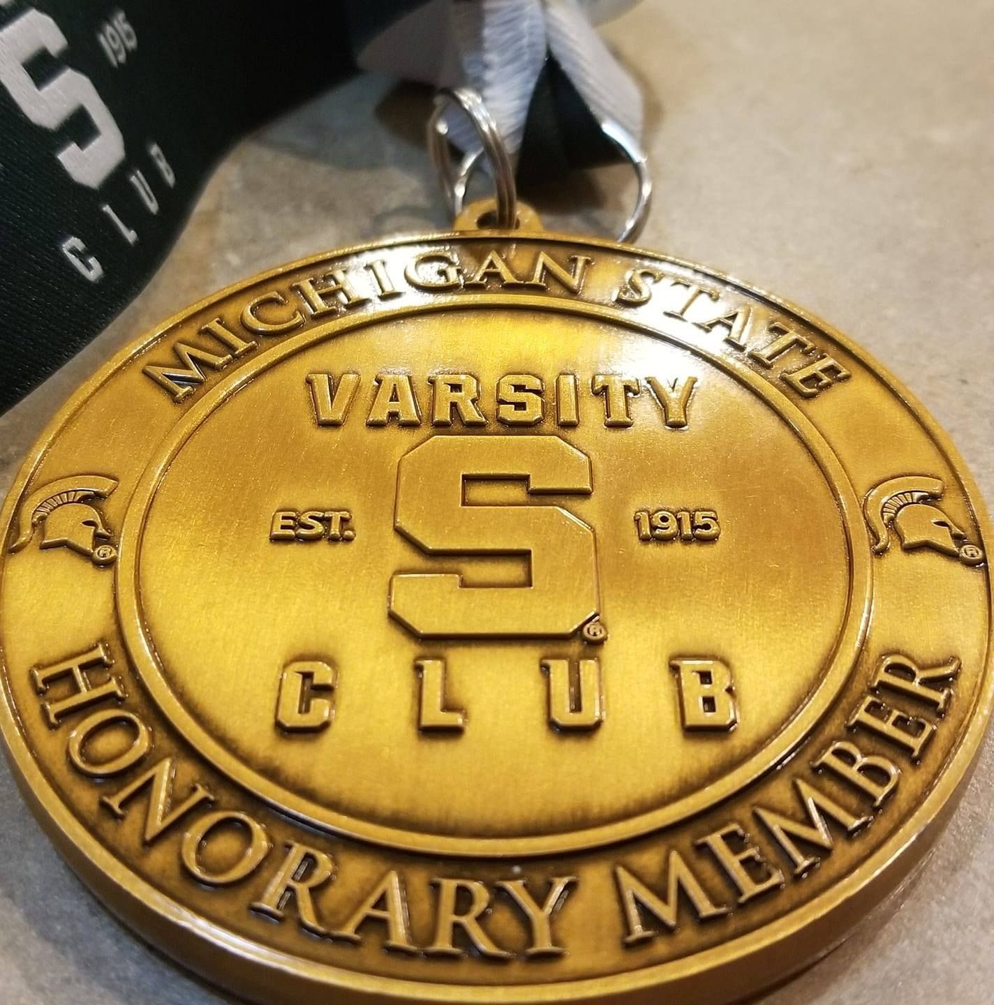 Gold Michigan State Varsity Club medal with 