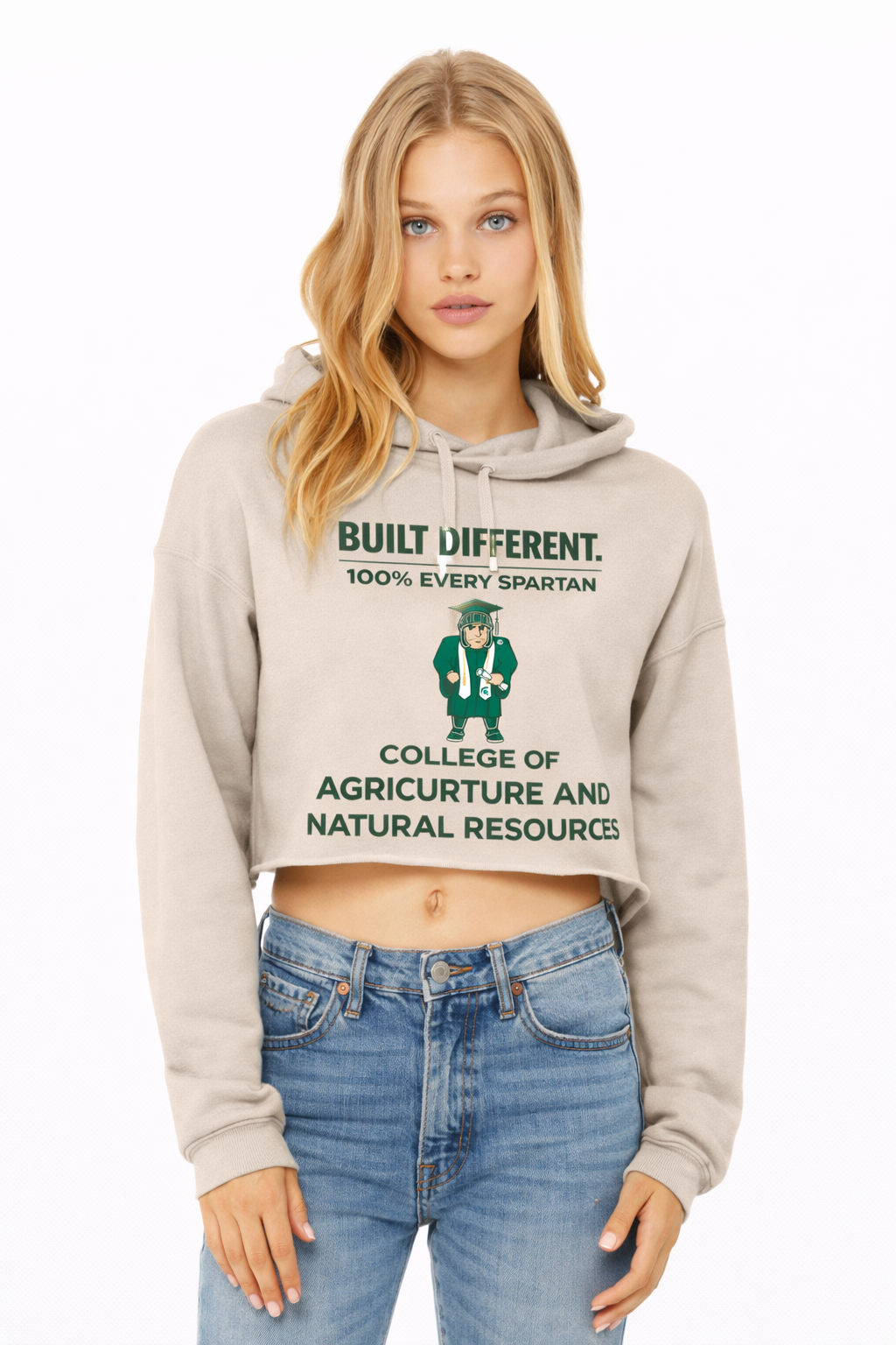 A model wears a tan crop-top hoodie with green text reading 