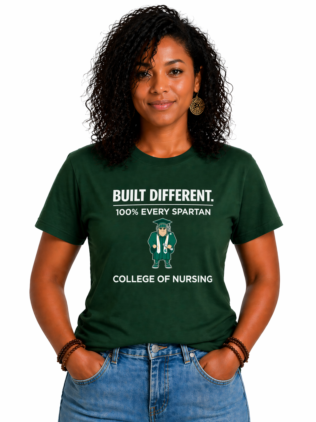 Woman in a dark green T-shirt with “Built Different” and college of nursing text, standing against a white background