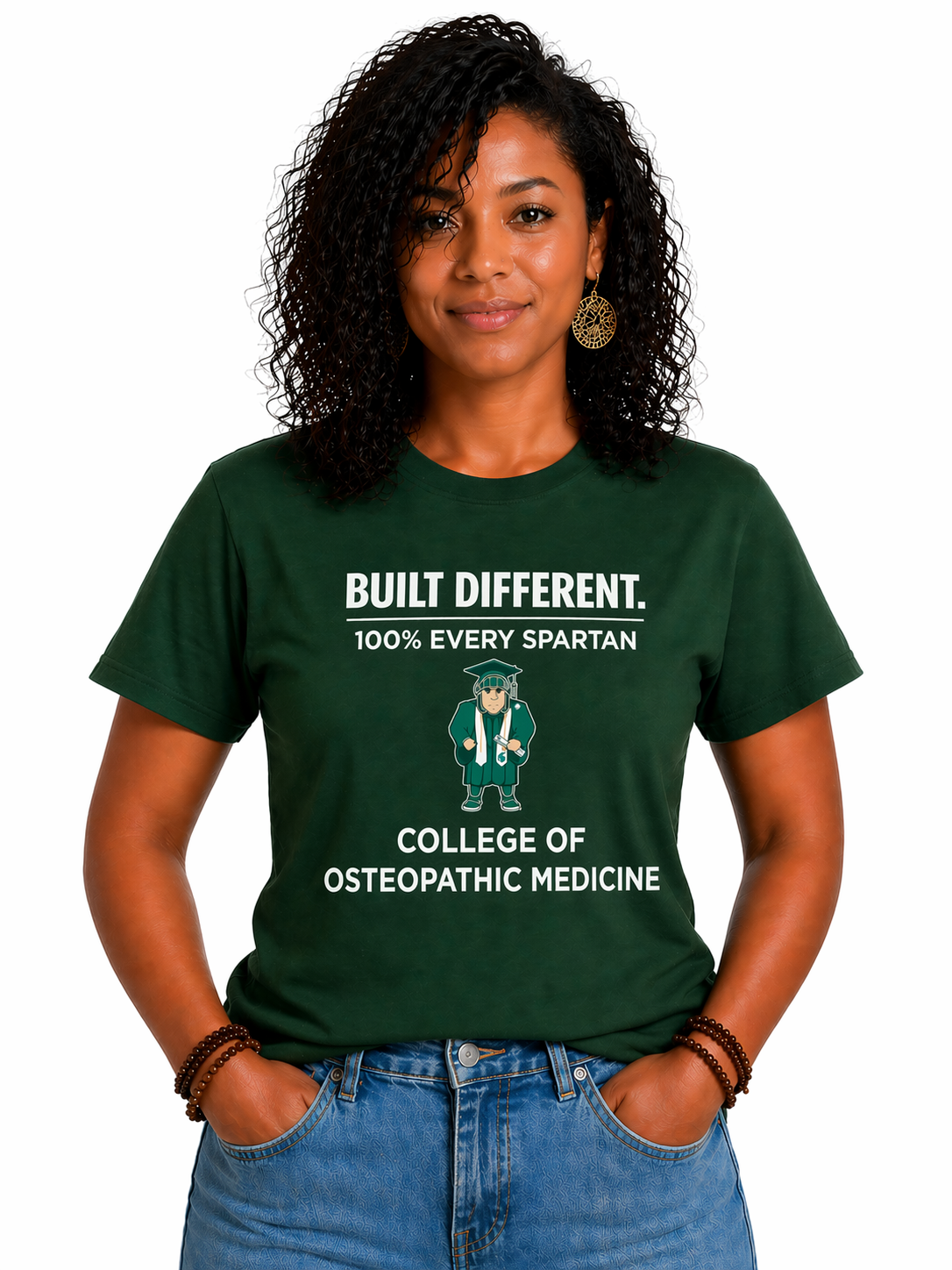Woman wearing a green “Built Different” College of Osteopathic Medicine T-shirt, standing against a white background.