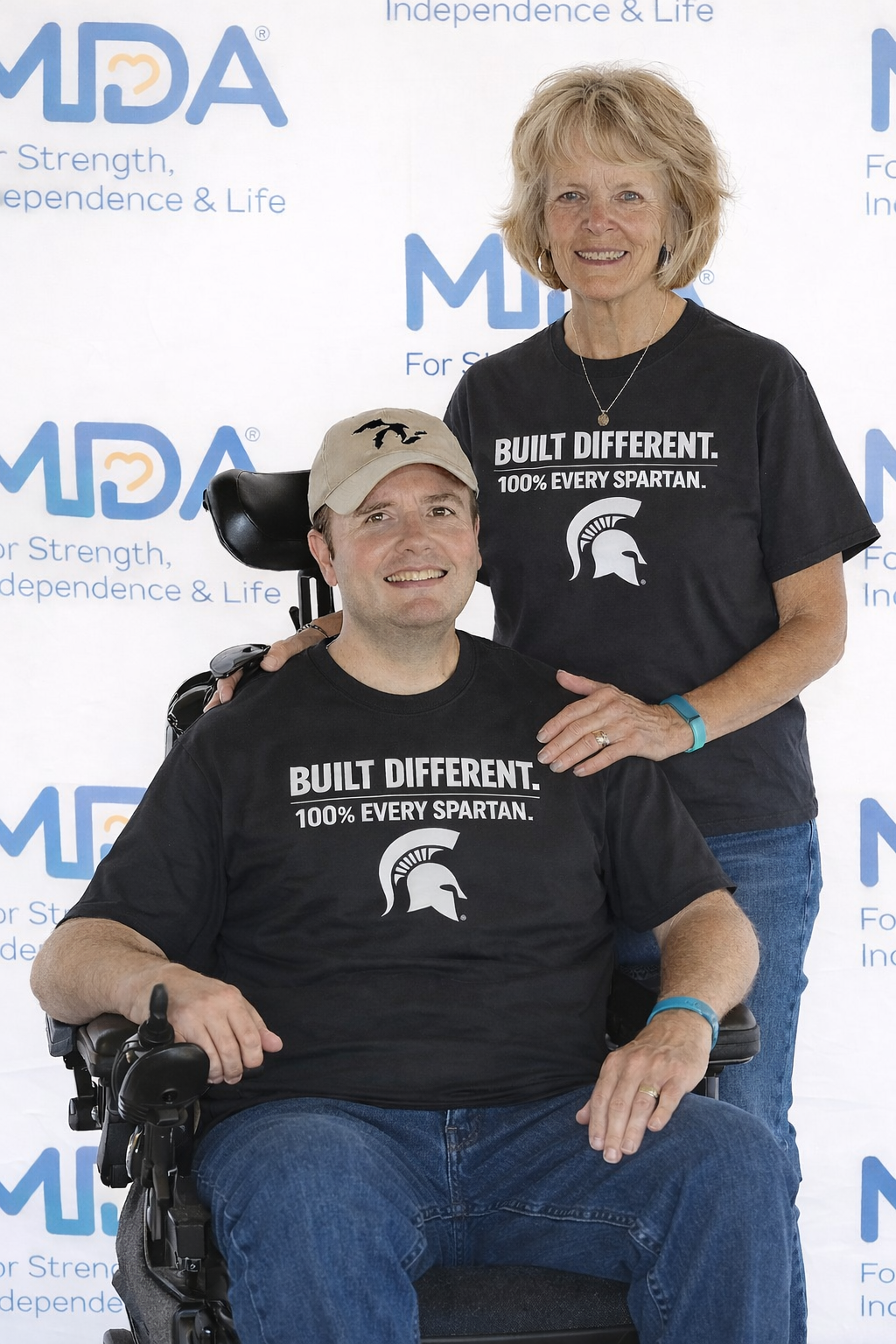 Man in wheelchair and woman wearing matching t-shirts that say 