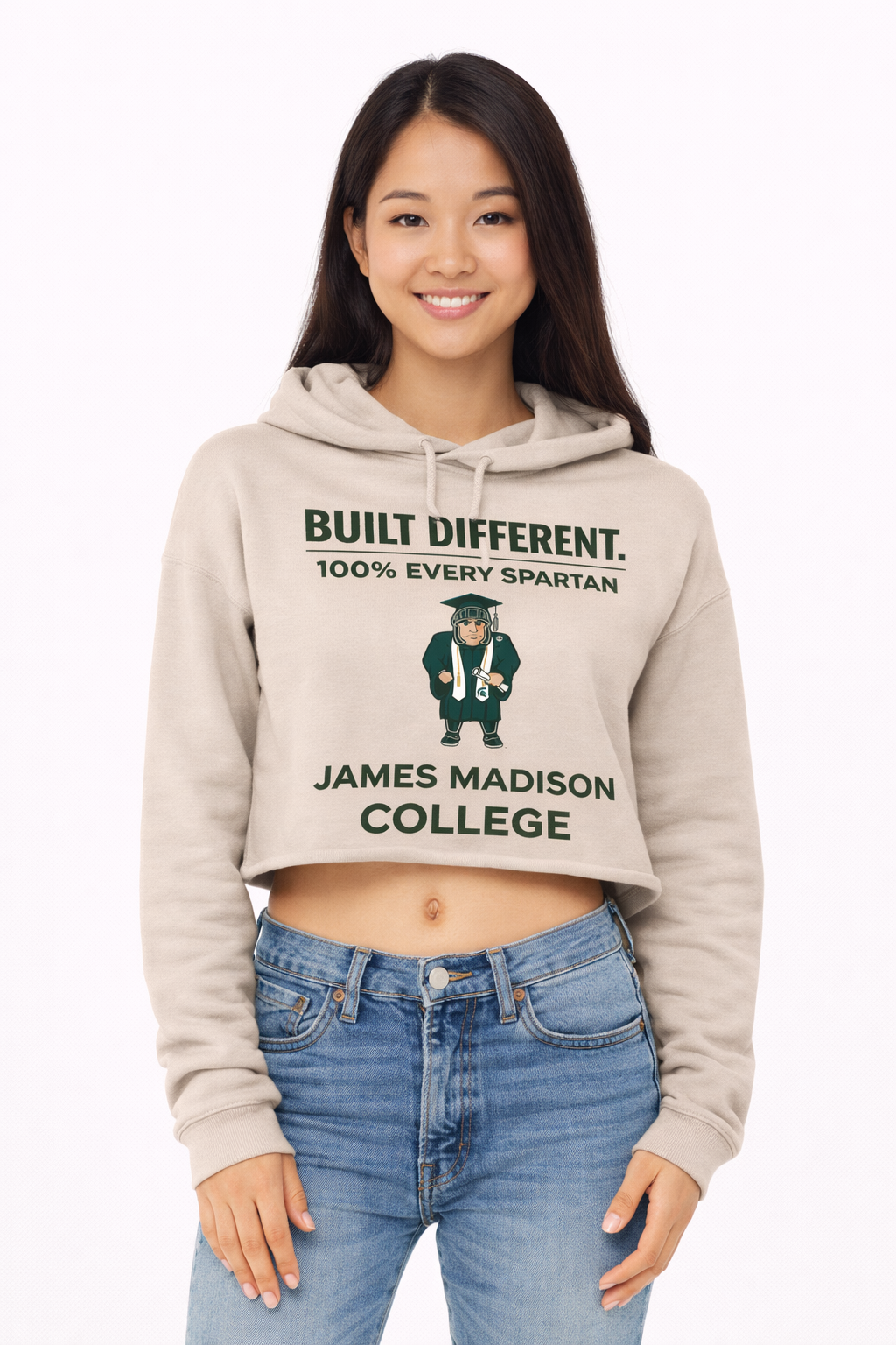 A woman wearing a tan cropped hoodie featuring a Spartan mascot graphic and the text 