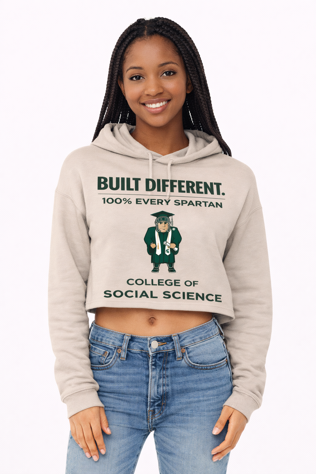 A woman wearing a tan cropped hoodie with a Spartan mascot graphic and the text 