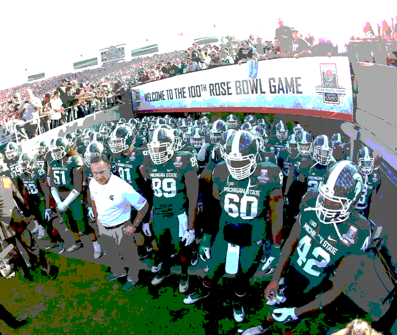 Football team in green and white uniforms entering a stadium tunnel under a banner.