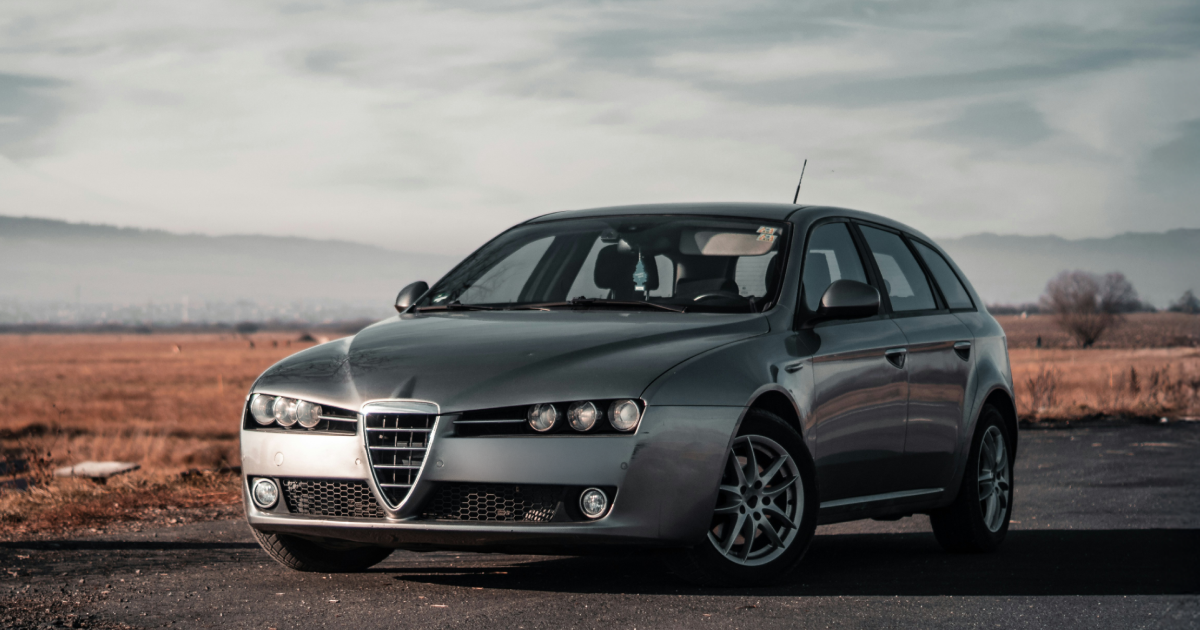 Silver Alfa Romeo 159 Sportwagon parked on a road in a rural setting.