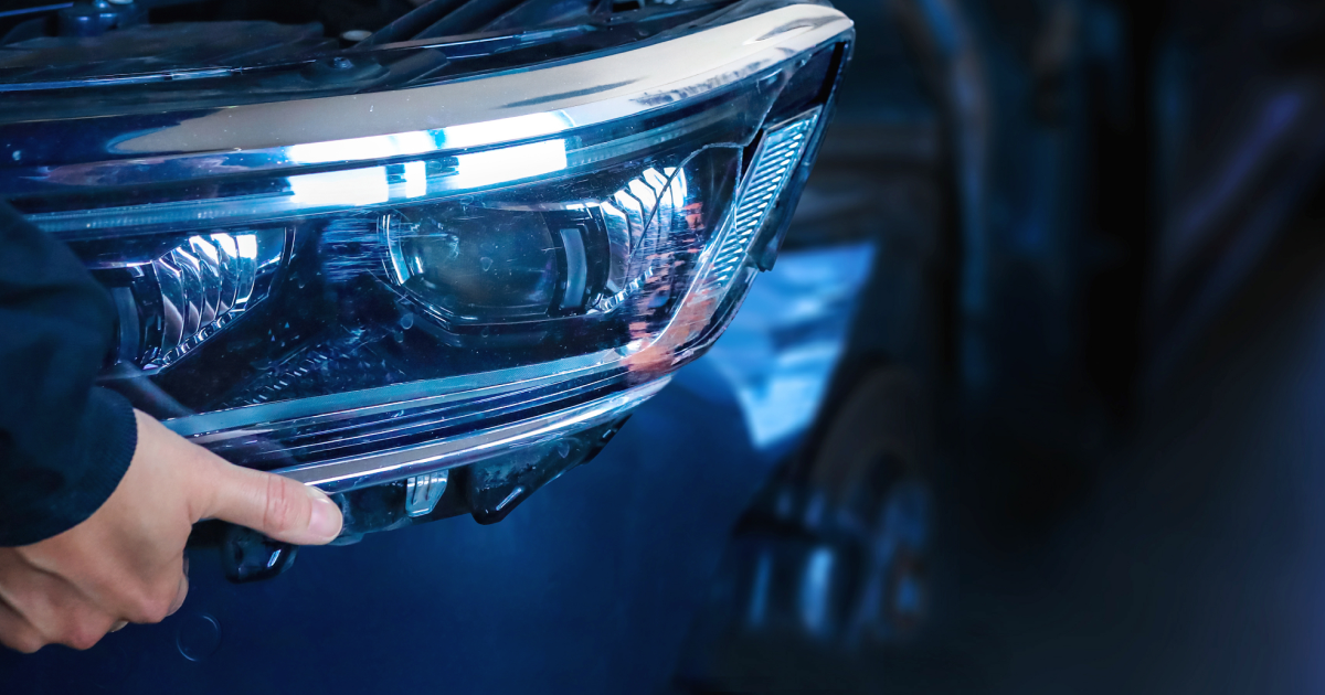 Person holding a blue car headlight, close-up.