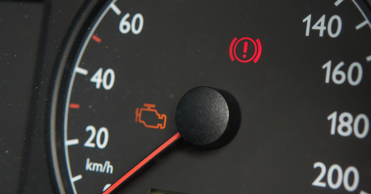 Dashboard with illuminated check engine and brake warning lights.