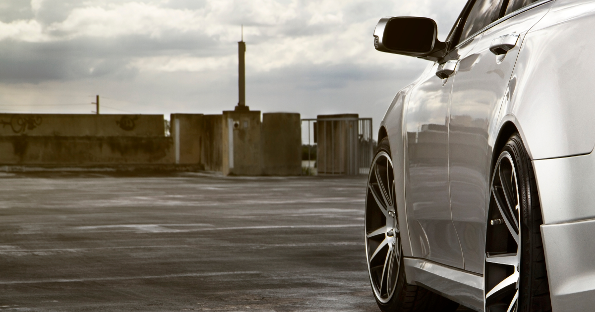 Silver car parked on a rooftop deck on a cloudy day.