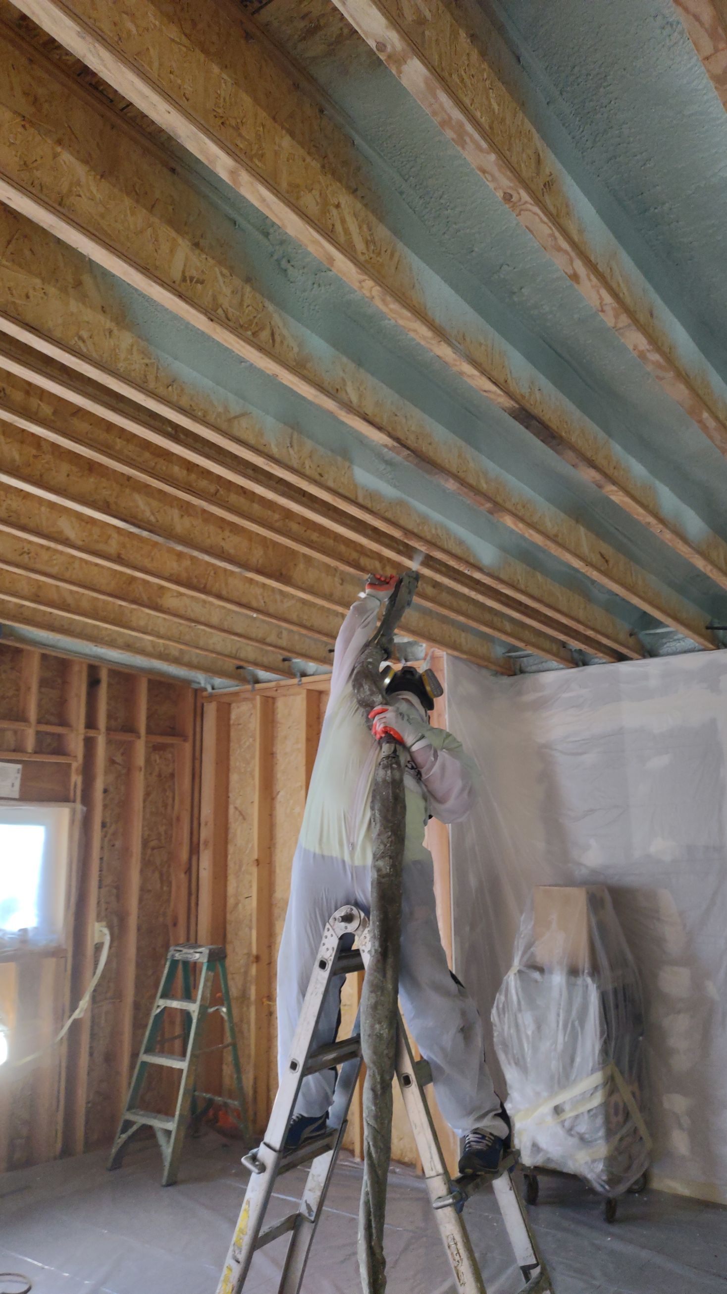 Worker applying spray foam insulation in Pierce County, WA.