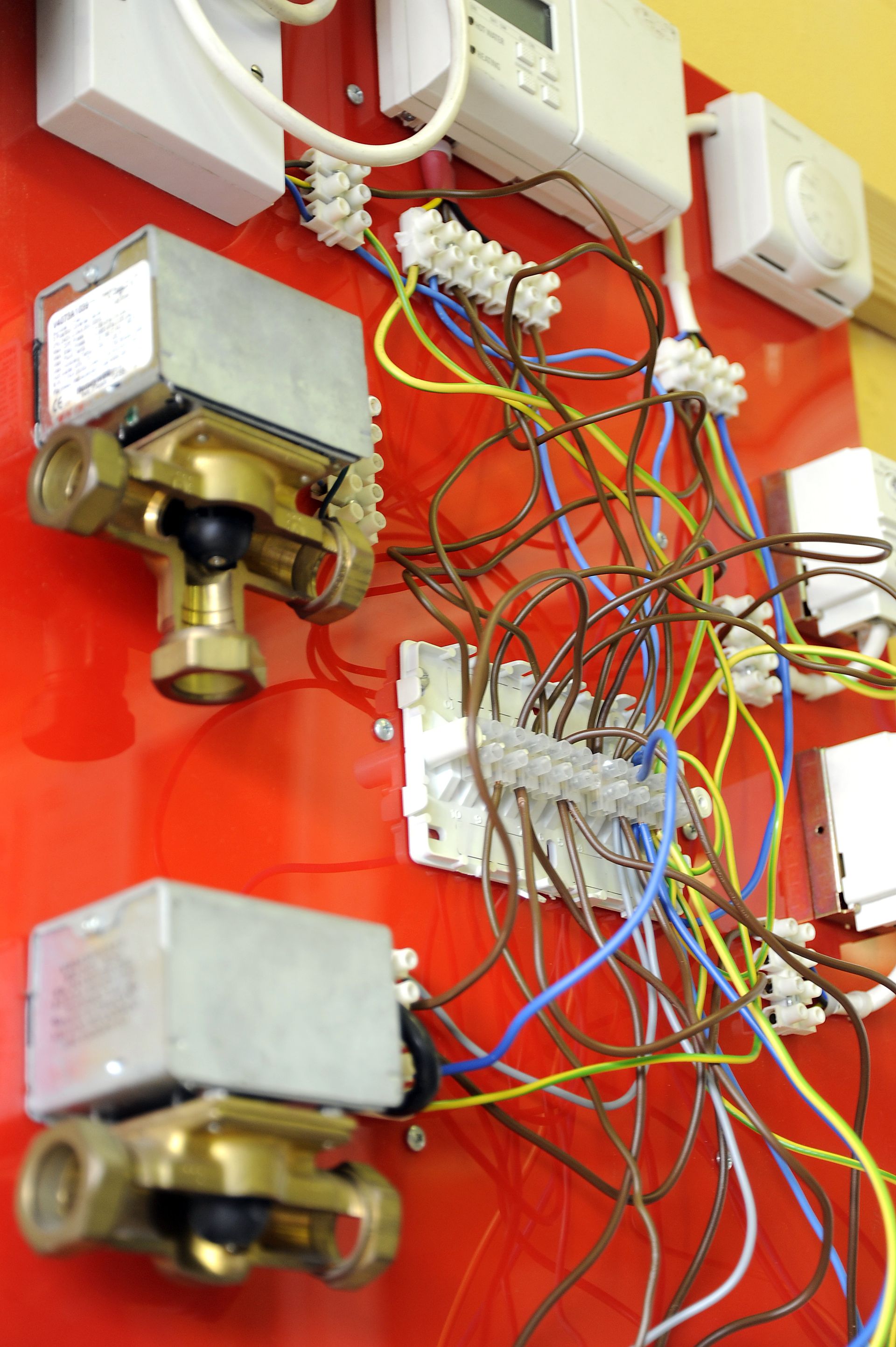 A bunch of wires are hanging on a red wall