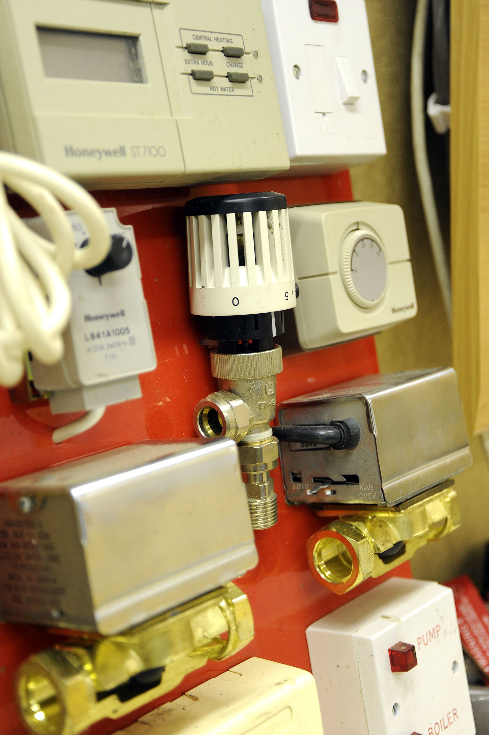 A wall with a bunch of electrical devices including a honeywell thermostat