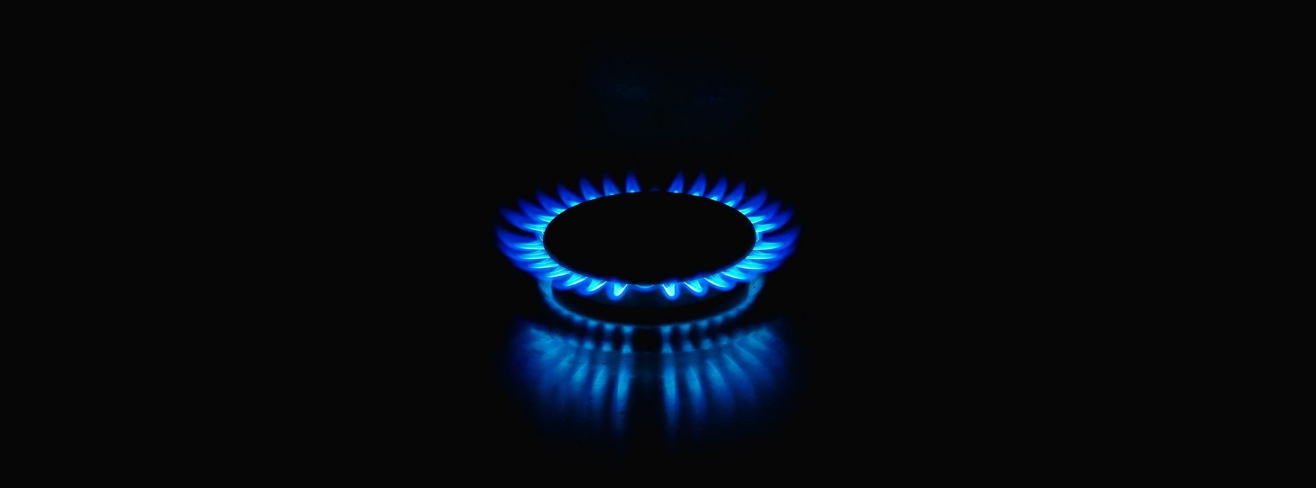 Blue gas flame burning in a dark setting.
