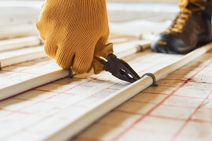 A person is installing underfloor heating on a floor.