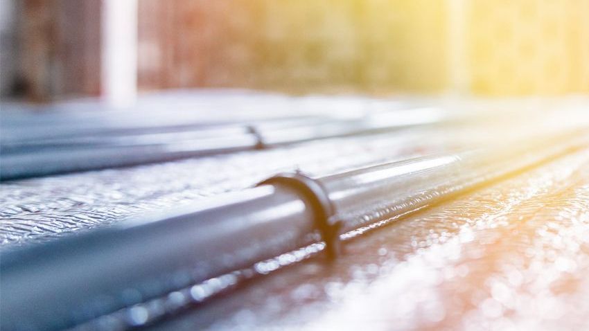 A close up of a bunch of underfloor heating pipes on the ground.