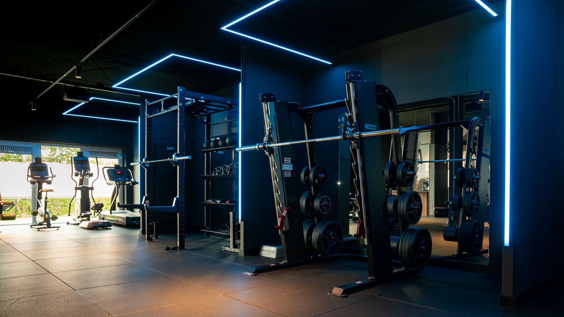 A diverse team collaborates around a table in a bright, plant-filled office, reviewing notes and a laptop.