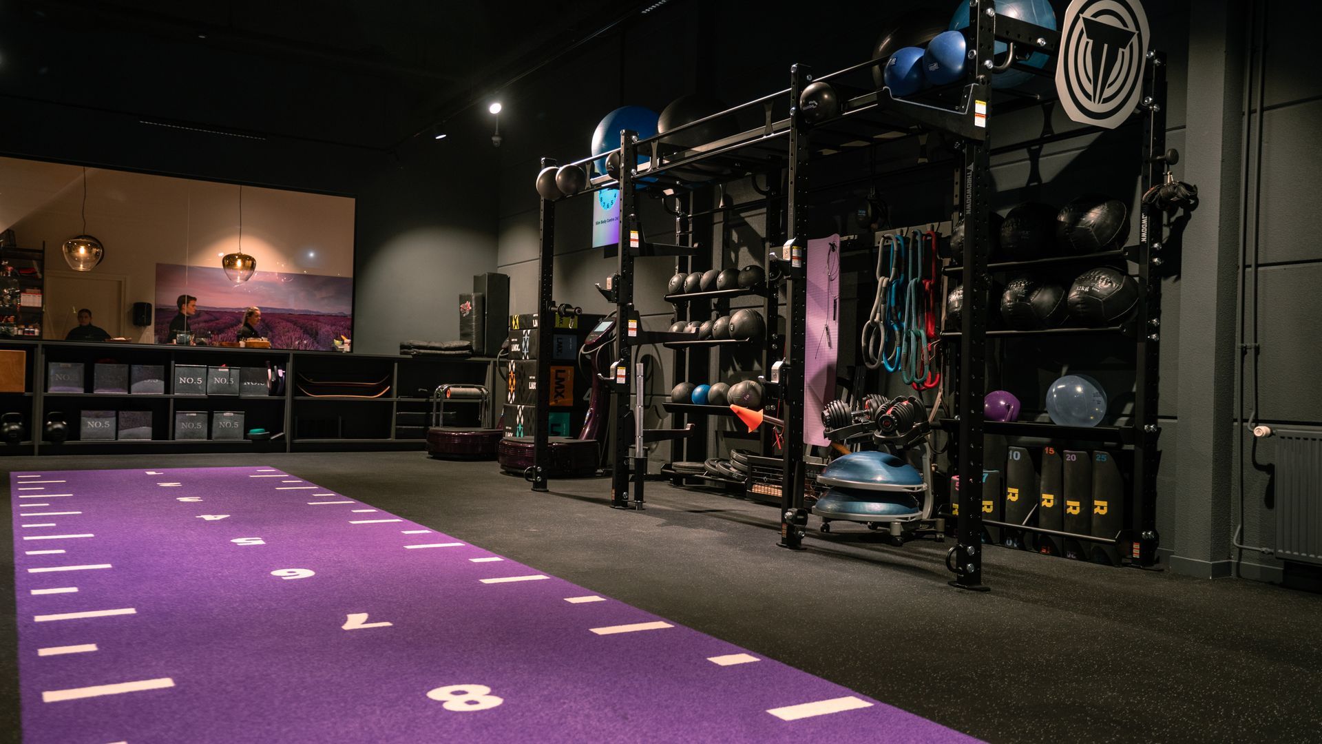 Purple carpeted event space with lighting rigs and equipment along a dark wall