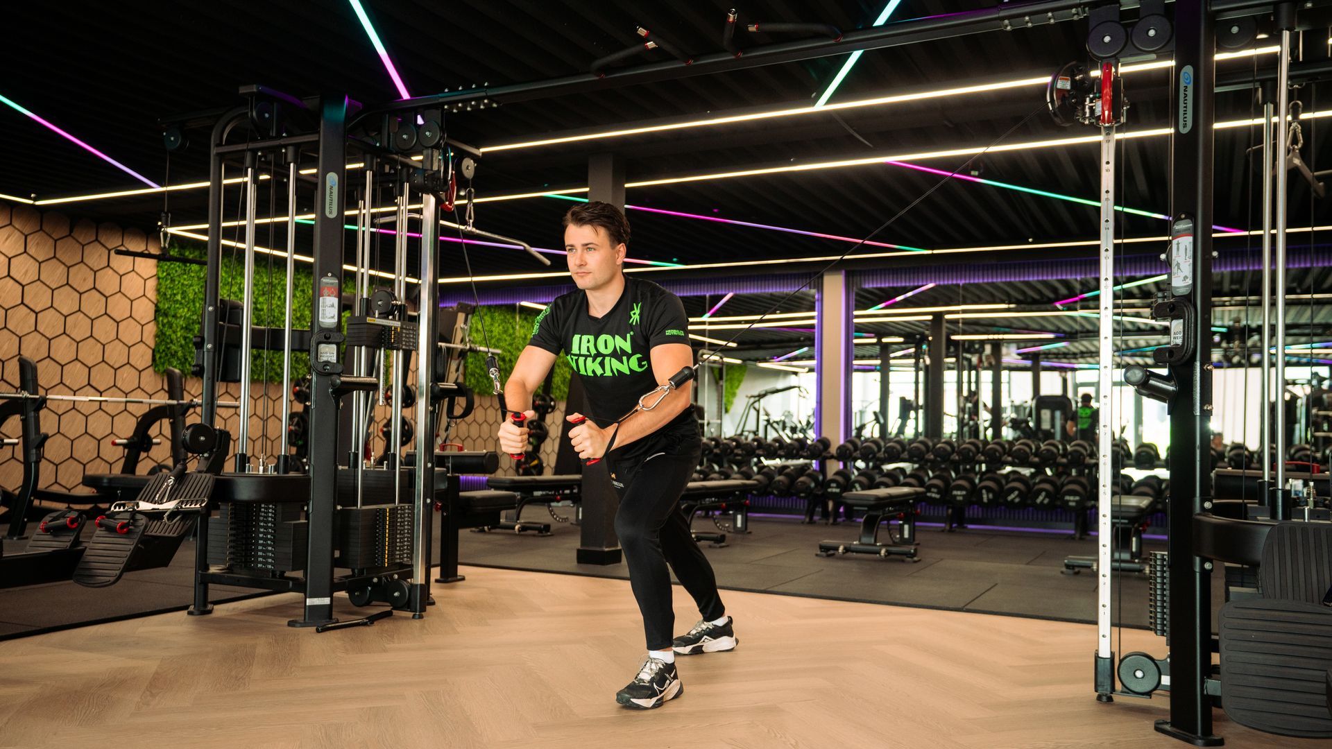 Person exercising with battle ropes in a neon-lit gym