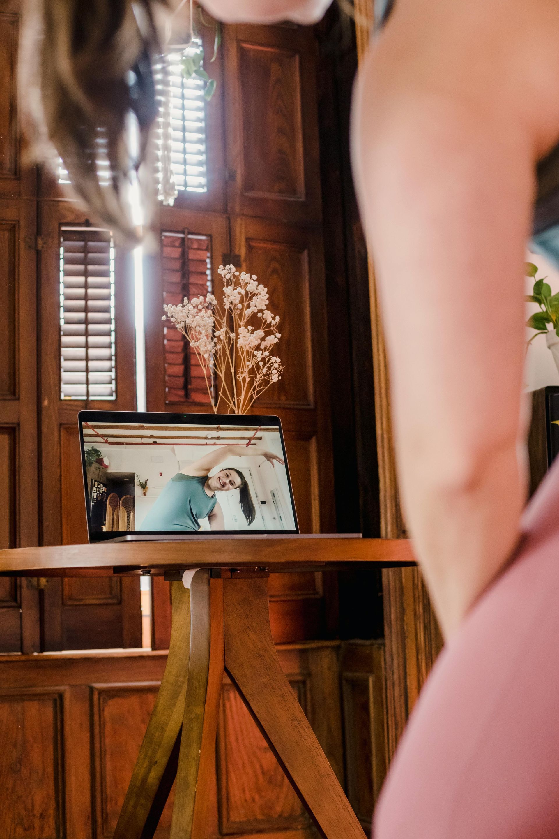 Framed photo on a wooden stand in a sunlit room, with a person partially visible in the foreground