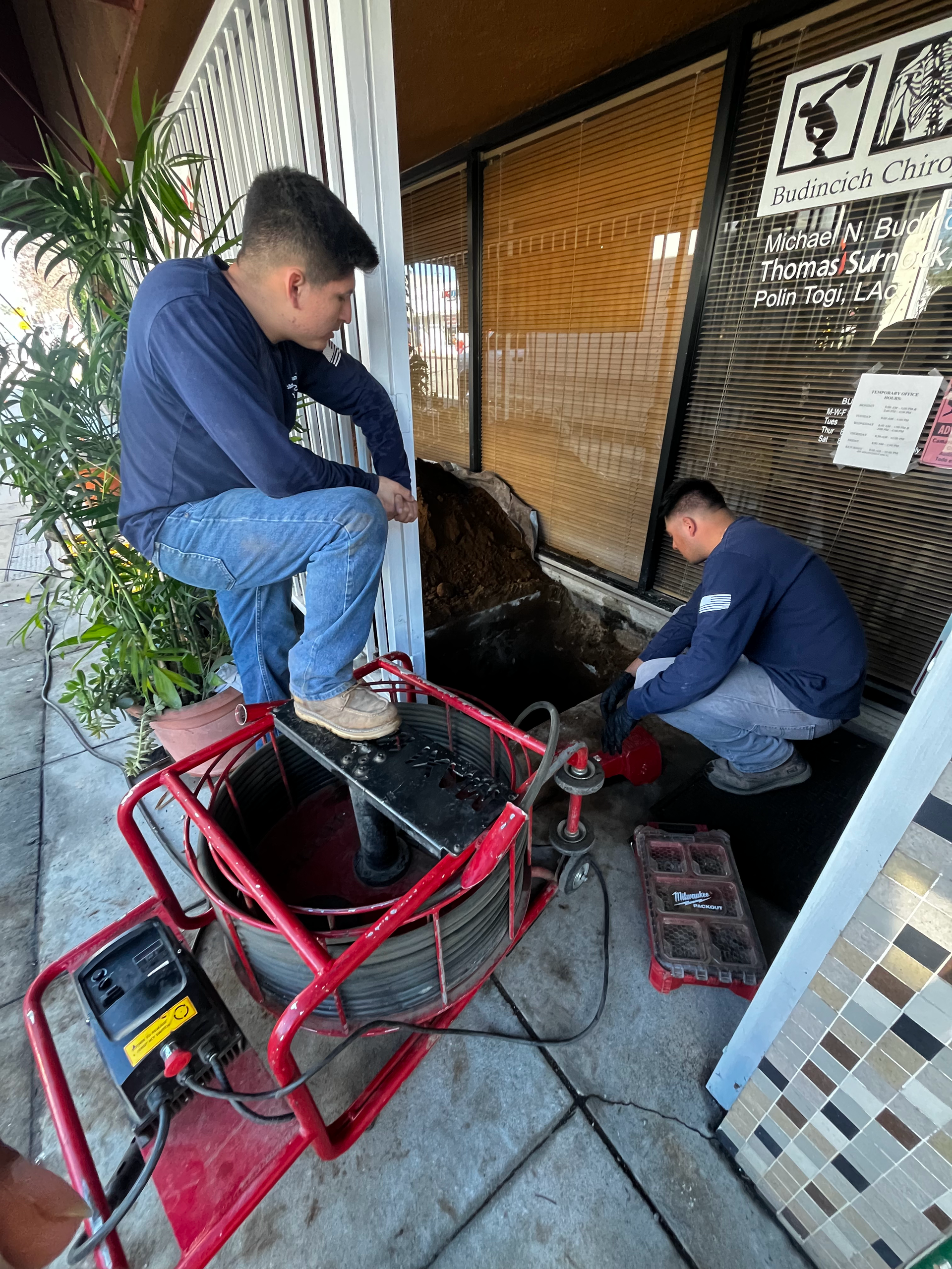 Two Men Are Working On a Drain Outside of a Building — Granada Hills, CA  — Future Plumbing