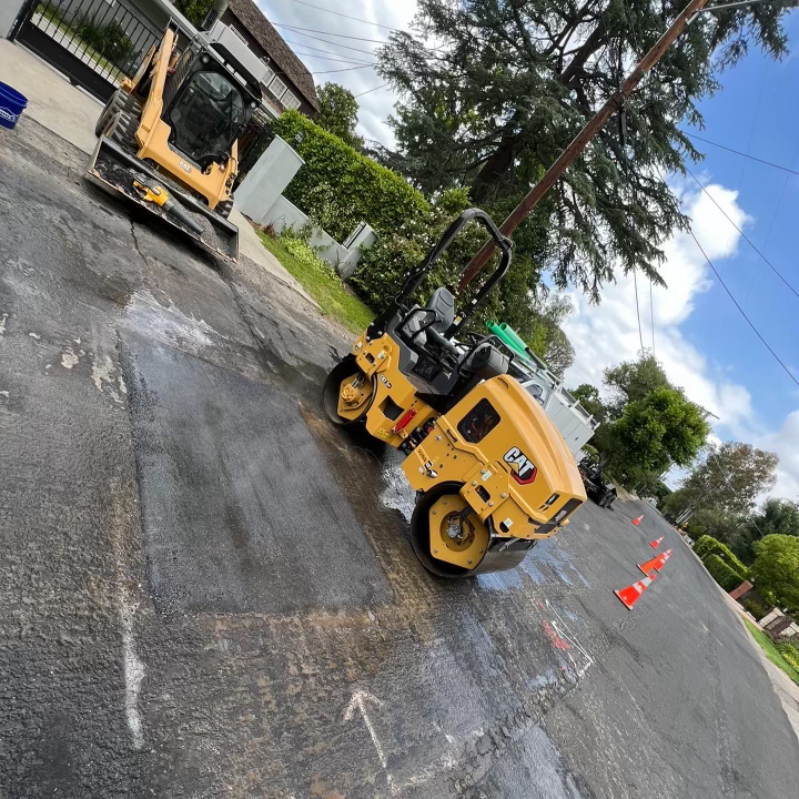 A Yellow Cat Roller Is Sitting on the Side of the Road — Granada Hills, CA  — Future Plumbing