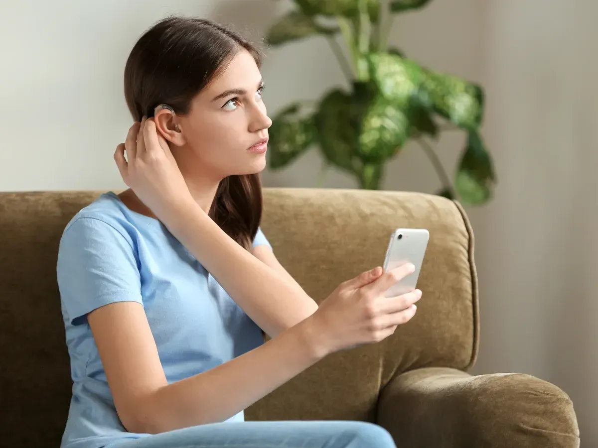 An image of a woman connecting her hearing to a smartphone app.