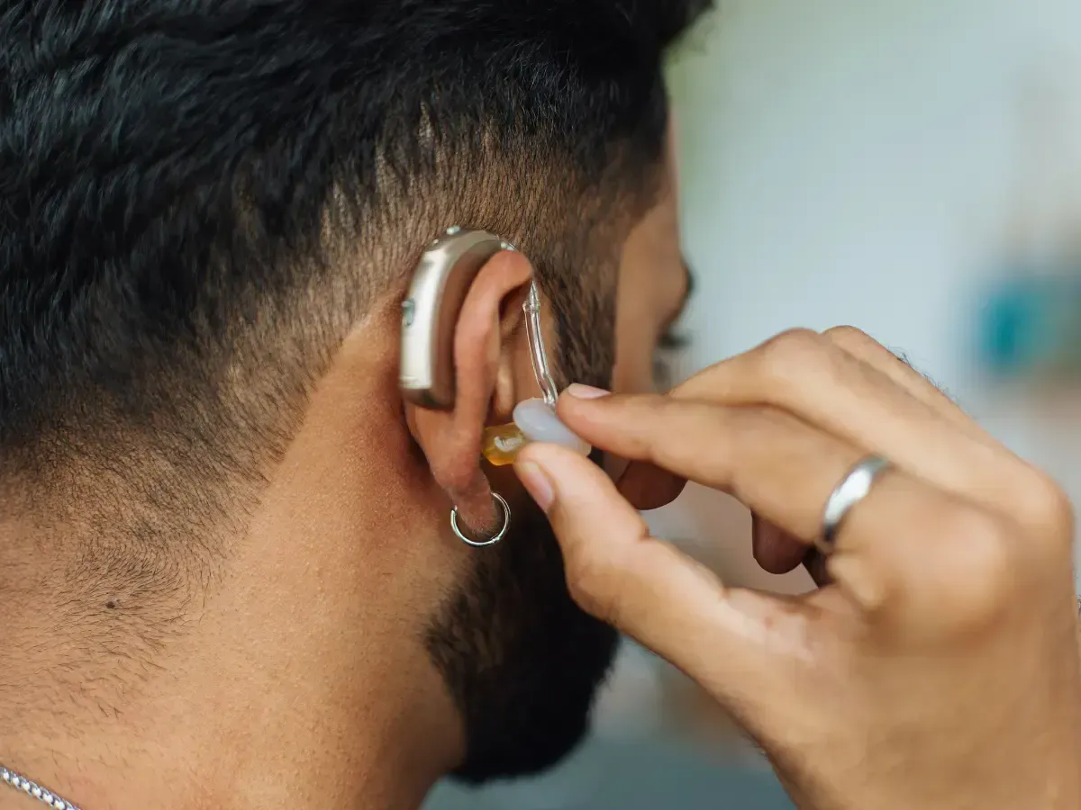 Close up photo of a man fixing his hearing aid