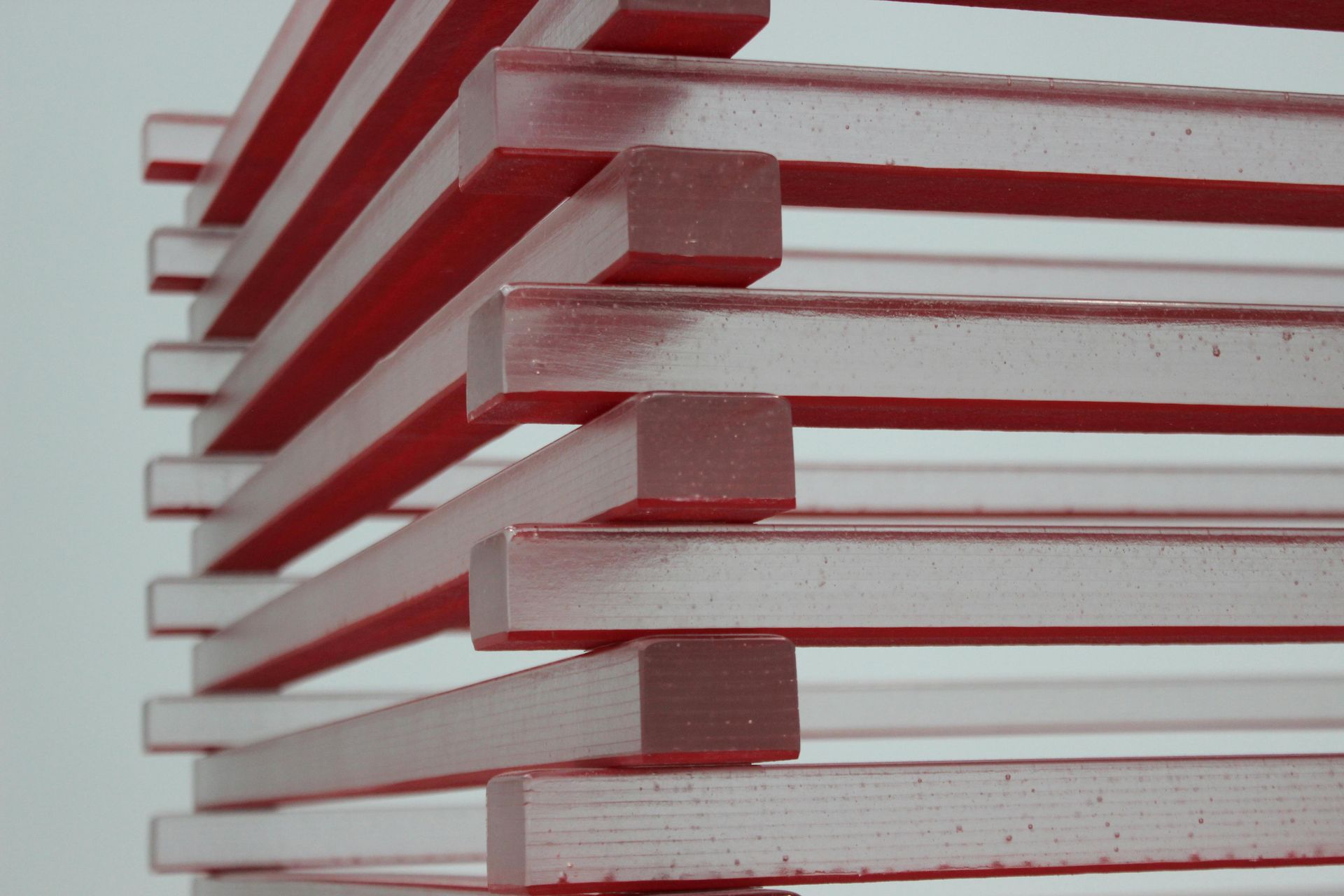 Red and clear square rods stacked in a spiral shape against a white background.
