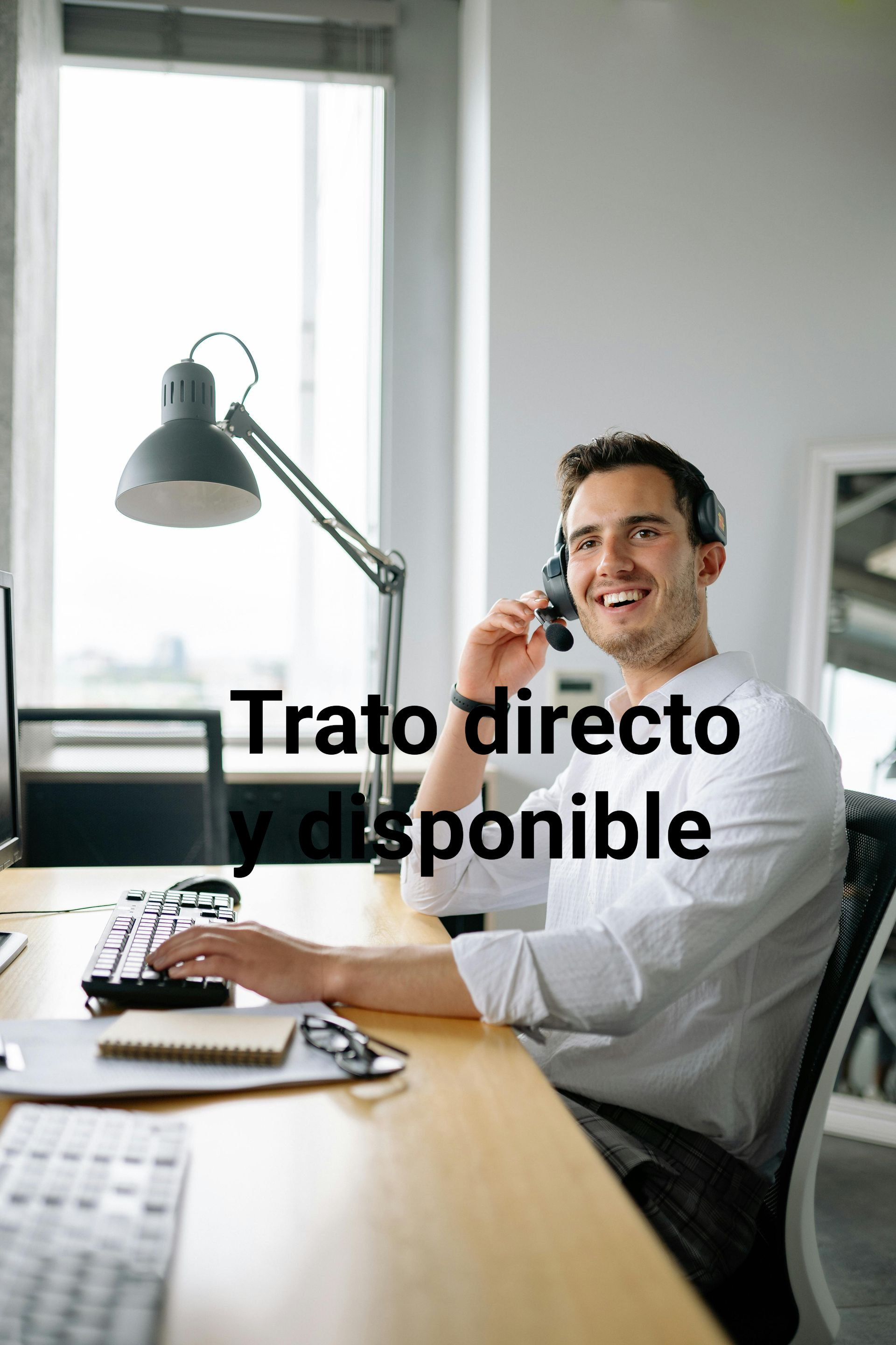 Man on headset at desk smiling,