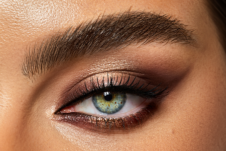 A close up of a woman 's eye with smokey eye makeup.