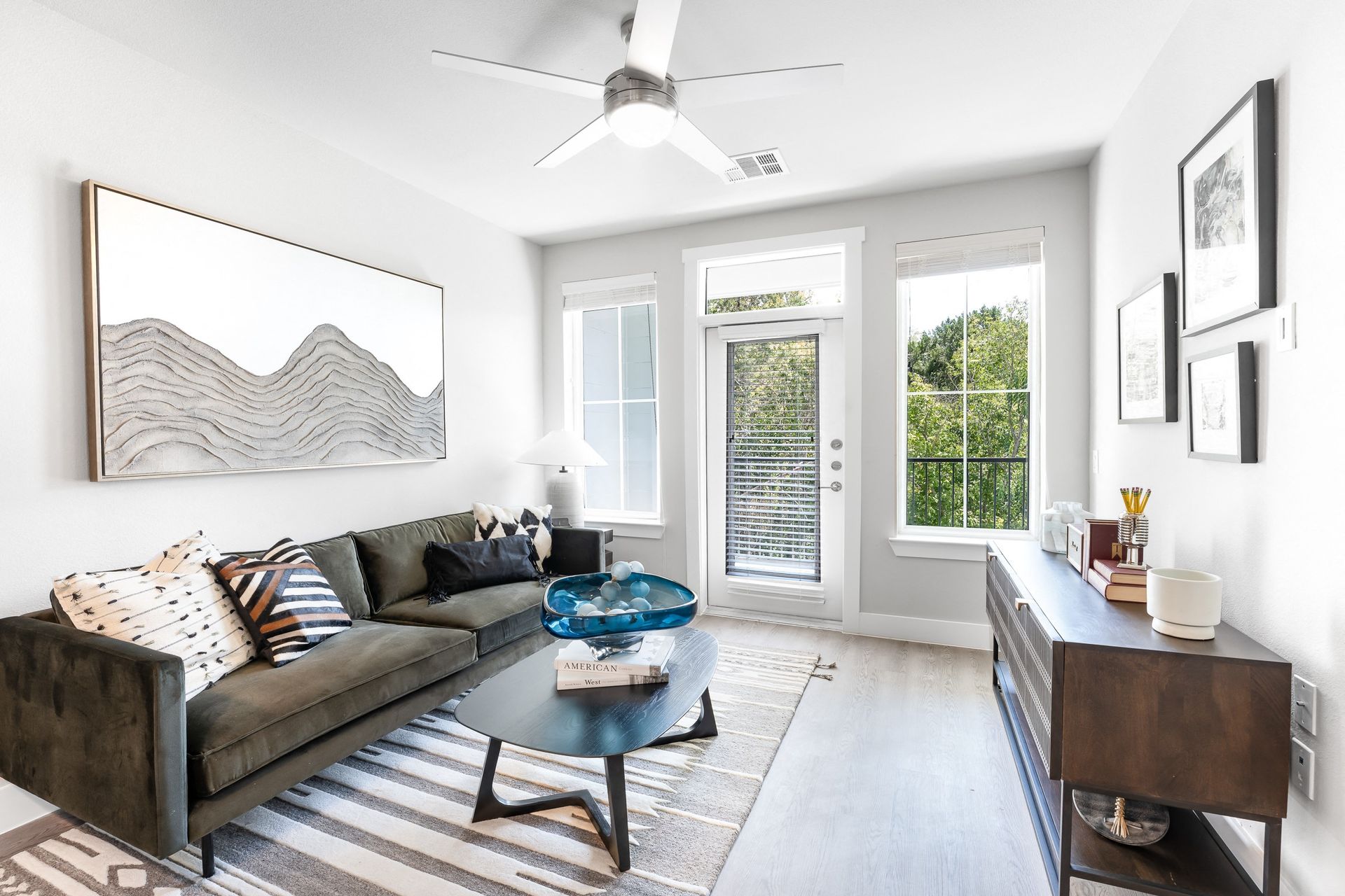 A living room with a couch , coffee table , and a ceiling fan at The Bennet, offers apartments for rent in South Austin.
