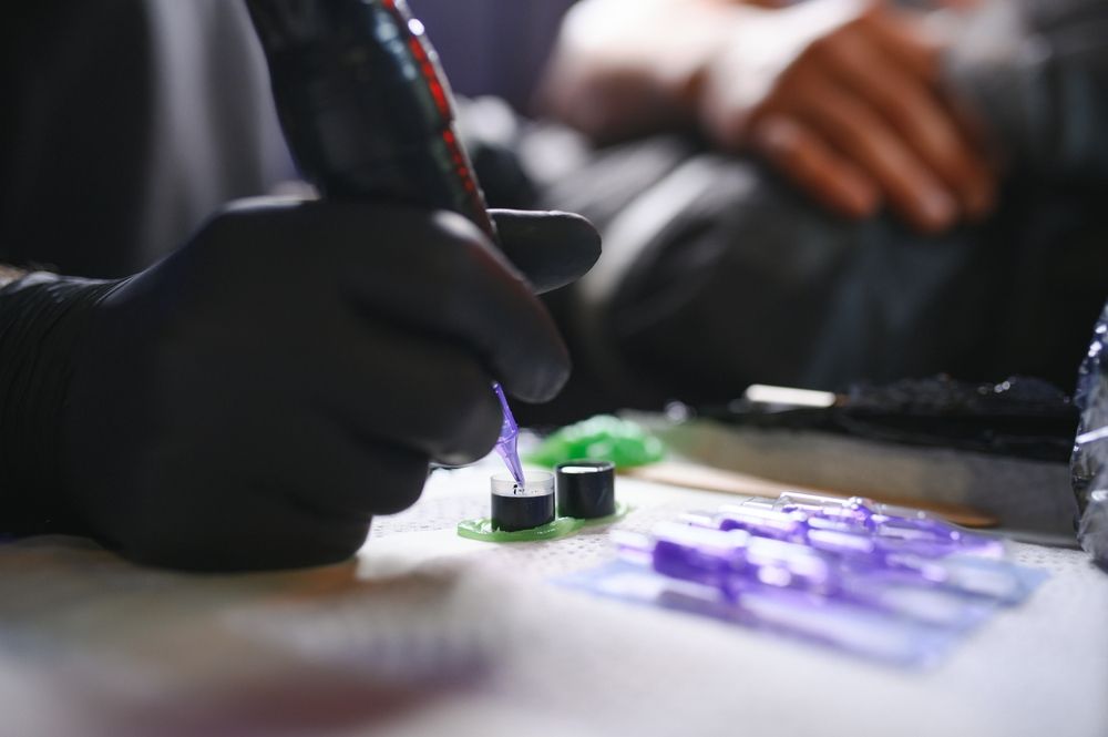 A close up of a person getting a tattoo with a machine.