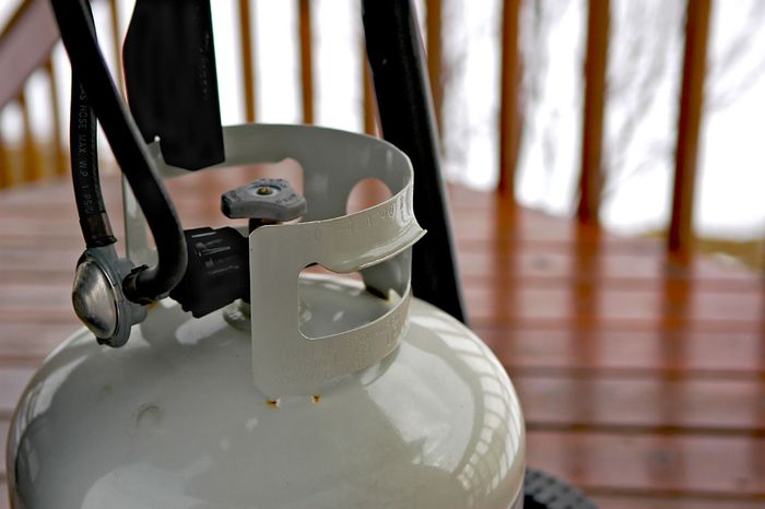 A propane tank is sitting on a wooden table