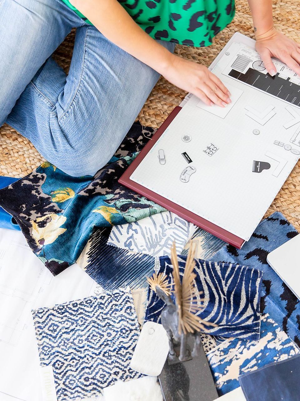 a woman is sitting on the floor looking at a blueprint