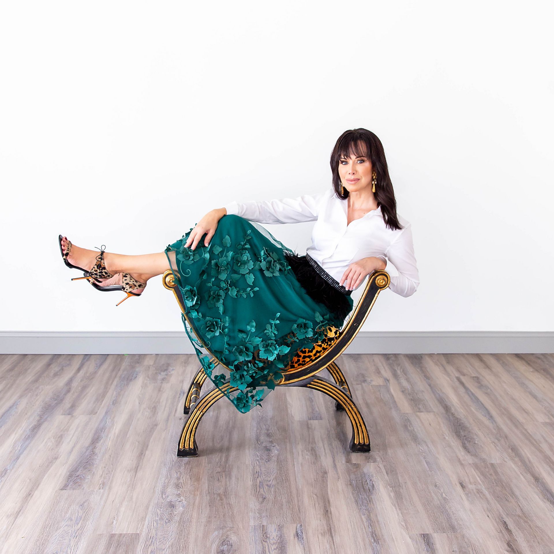 Carrie Riddle Interior Design sits on a chair with her legs crossed