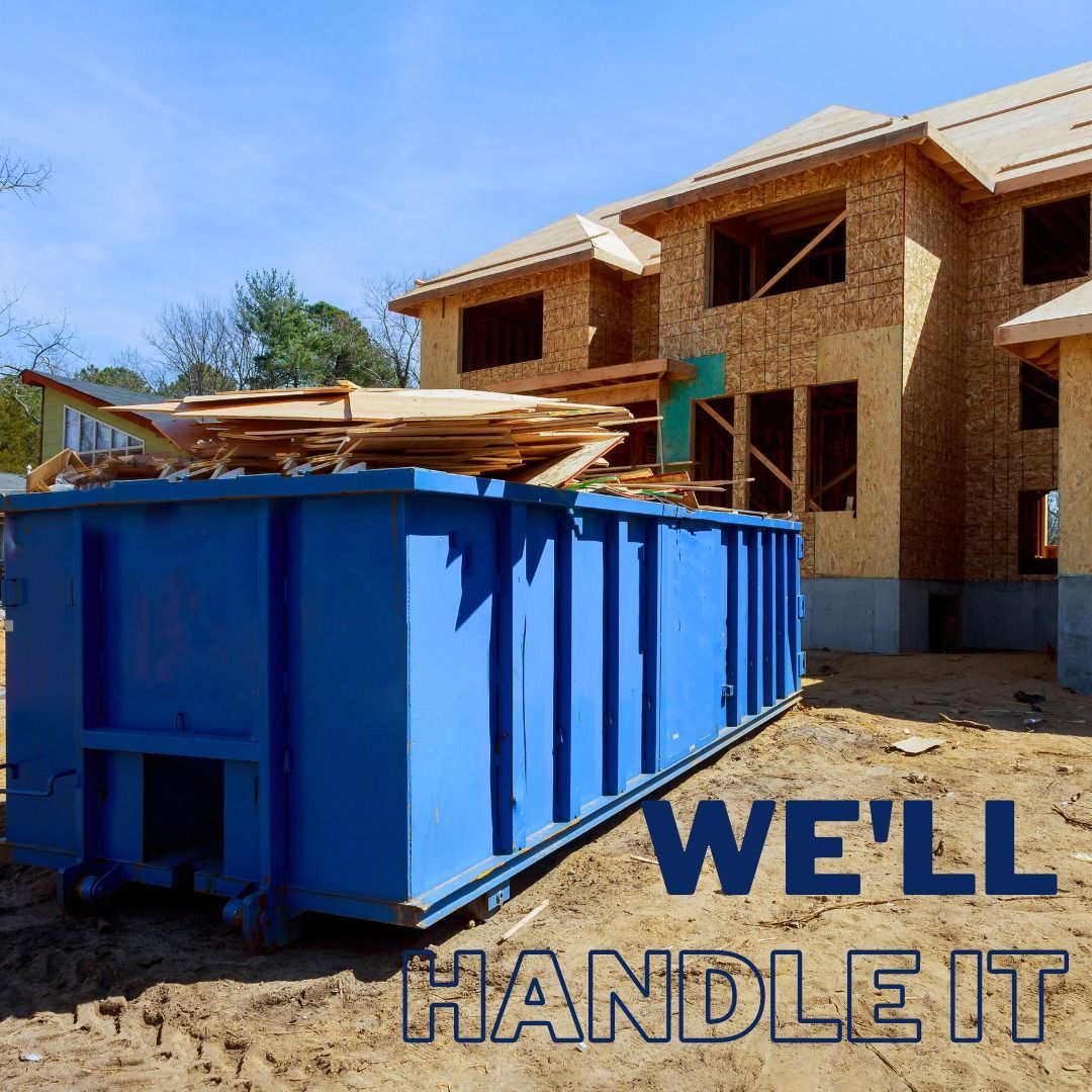 Blue dumpster full of construction debris in front of a house under construction; 