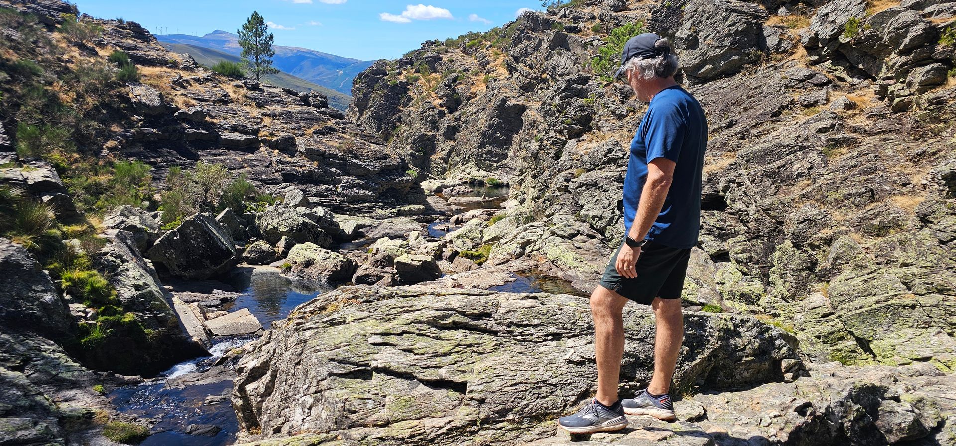 Turista olha com alegria e satisfação o rio Olo a na Serra do Alvão percorrer o seu curso escarpado 