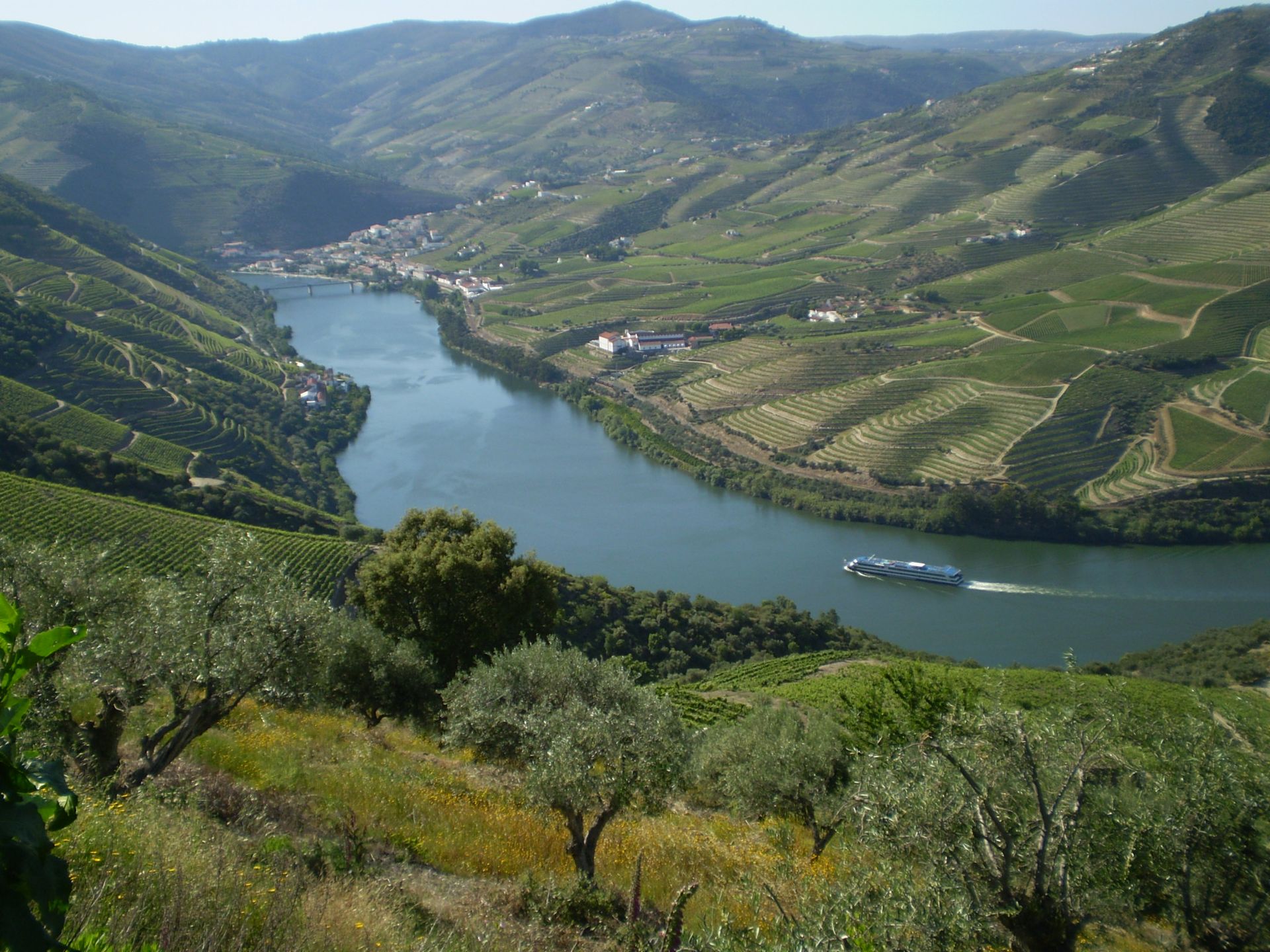barco no rio douro serpenteia as montanhas cheias de vinhas no alto douro vinhateiro