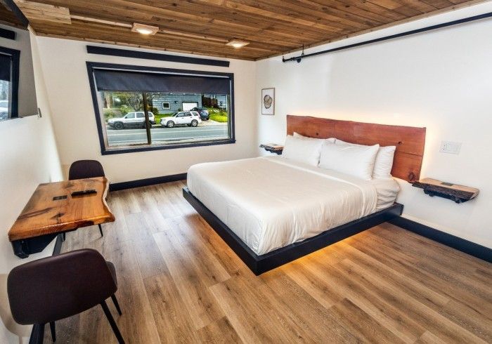 A hotel room with a king size bed and a wooden table.